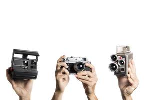 film vintage e videocamere tenute da mani su sfondo bianco foto
