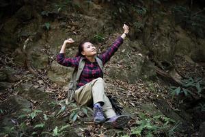 donna escursionista nella foresta prendendo un periodo di riposo foto
