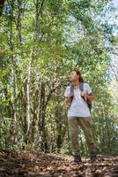 escursionista attivo giovane donna che cammina attraverso la foresta