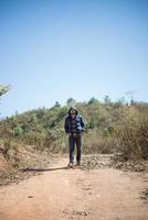 escursionista con lo zaino che cammina attraverso la foresta godendosi l'avventura in vacanza foto