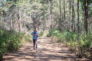 turista con lo zaino che cammina attraverso la foresta foto