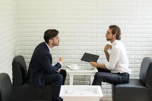 giovane imprenditore parlando con un collega in un moderno business lounge foto