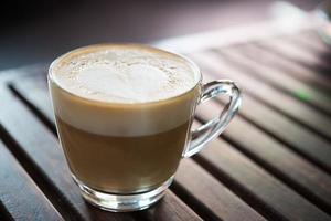 primo piano della tazza del cappuccino con il modello del latte a forma di cuore al caffè foto