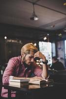 libro di lettura uomo barbuto hipster nella caffetteria. foto