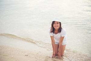 felice giovane donna in vacanza in spiaggia foto