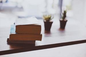 fiore di cactus con una pila di libri sul tavolo di legno foto