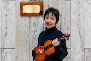 giovane Cinese femmina violino creatore mostrando sua appena fatto violino all'aperto foto