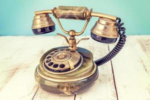 d'oro colorato Vintage ▾ telefono al di sopra di un' bianca di legno tavolo foto