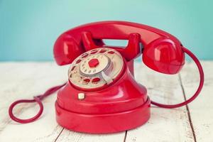 rosso colorato Vintage ▾ telefono al di sopra di un' bianca di legno tavolo foto