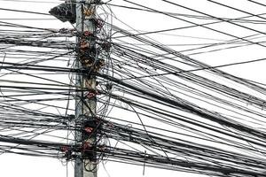 disordinato caos di cavi con fili su elettrico polo su bianca sfondo, il molti elettrico filo su il energia poli foto
