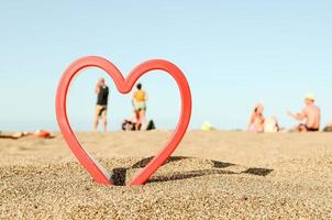 rosso cuore su il spiaggia foto