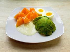 salutare cibo di fresco frutta e uova su bianca piatto su tavolo, superiore Visualizza foto