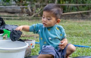 poco bambino pale suolo in pentole per preparare impianti per piantare. bambino piccolo ragazzo scavando suolo per piantare per La madre di poco aiutante. giardinaggio. Hobby a casa orticoltura. tempo libero attività concetto foto