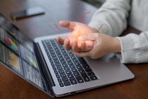 ufficio sindrome con mano dolore di professionale patologia, donna Tenere sua mano dolore a partire dal utilizzando il computer portatile o smartphone lungo tempo, salute cura e medico concetto, polso dolore. foto