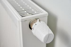 mano girare calore termosifone pomello termostato foto