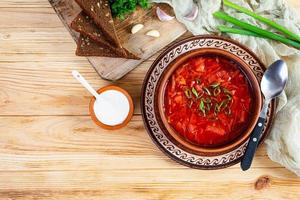 tradizionale ucraino borscht con verde cipolla e acida crema. delizioso barbabietola la minestra nel ciotola con segale pane. superiore Visualizza foto