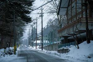 niko, Giappone - 26 gennaio 2023. tungsteno lampada e un' giapponese villaggio cartello, pesante neve coperto strada a heike no sato villaggio nel tochigi prefettura, nikko città, foto