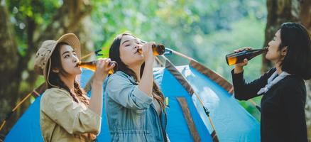 giovane donna rallegrare e bevanda bevanda davanti di campeggio tenda foto