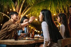 contento asiatico amici applauso con arrostito tacchino cena all'aperto - gruppo di persone avendo divertimento nel nuovo anno festa. le persone, cibo e bevanda stile di vita concetto notte festa, persone e celebrazione concetto. foto