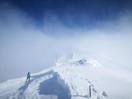 sciare attraverso un' tempesta di neve su il montagna foto