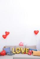 Foglio amore palloncini e i regali su un' divano con bianca parete nel sfondo per San Valentino giorno, La madre di giorno sorpresa design concetto. foto