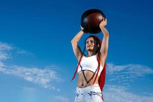 sfondo cielo. atletico donna con med sfera. forza e motivazione.foto di sportivo donna nel alla moda abbigliamento sportivo foto