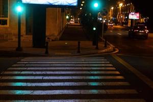 notte strade, pedone zebra traversata, traffico leggero foto