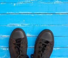 Uomini vecchio scarpe da ginnastica su un' blu di legno superficie foto