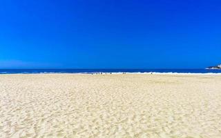 sole spiaggia sabbia persone onde palme nel puerto escondido Messico. foto