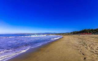 sole spiaggia sabbia persone onde palme nel puerto escondido Messico. foto