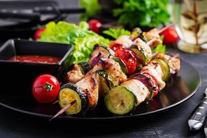 grigliato carne spiedini, pollo shish kebab con zucchine, pomodori e rosso cipolle. barbecue cibo. foto