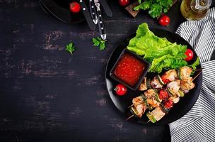 grigliato carne spiedini, pollo shish kebab con zucchine, pomodori e rosso cipolle. barbecue cibo. superiore Visualizza foto