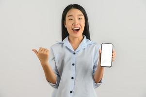 ritratto di giovane asiatico donna esprimendo sorpresa mentre utilizzando mobile Telefono isolato al di sopra di bianca sfondo foto