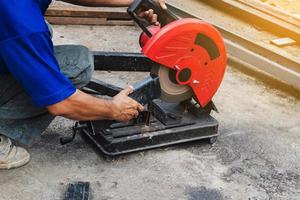 lavoratore uomo taglio acciaio con un' circolare acciaio taglierina. foto