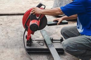 lavoratore uomo taglio acciaio con un' circolare acciaio taglierina. foto