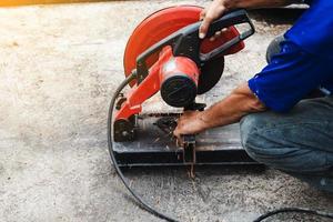 lavoratore uomo taglio acciaio con un' circolare acciaio taglierina. foto