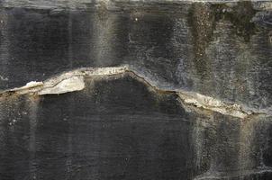 colore nero cemento parete ha crepe e peeling dipingere. foto