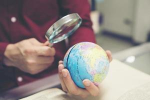 giovane studente tenendo in mano il modello di terra foto