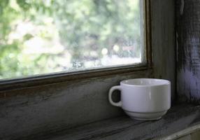 tazza di caffè sulla finestra foto