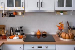 il interno di il in stile scandinavo bianca cucina è decorato con zucche per Halloween. autunno umore, casa arredamento per il vacanza foto