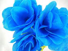 un' blu ornamentale fiore il cui, di chi petali siamo fatto di stoffa e il stelo è fatto di plastica su un isolato bianca sfondo foto