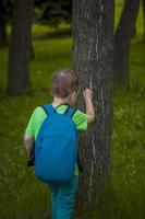 ritratto di un' bambino, un' ragazzo contro il sfondo di impianti nel un aria aperta parco. figli, viaggio. stile di vita nel il città. centro, strade. foto