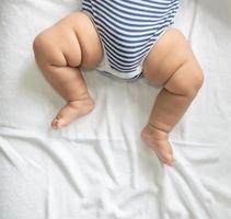 i piedi del bambino in un letto bianco foto