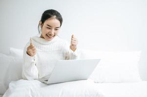 giovane donna che indossa una camicia bianca che gioca sul suo computer portatile