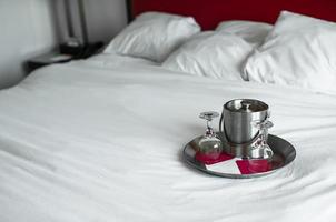bicchieri e metallo secchio per coppia nel il Camera da letto per romantico notte foto