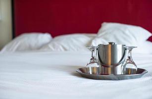 bicchieri e metallo secchio per coppia nel il Camera da letto per romantico notte foto