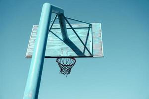 vecchio abbandonato strada pallacanestro cerchio e blu cielo sfondo foto