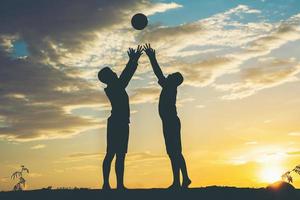 silhouette di bambini che giocano a calcio calcio foto