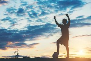 silhouette di bambini che giocano a calcio calcio foto