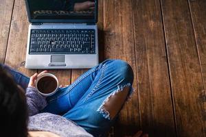 donna che tiene un caffè con un computer portatile foto